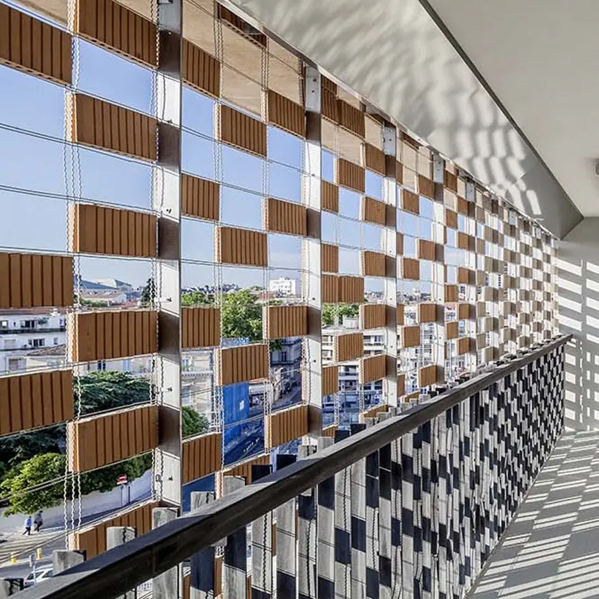 Vista desde el interior de una planta del aparcamiento a través del tejido cerámico, con piezas de arcilla dispuestas en damero