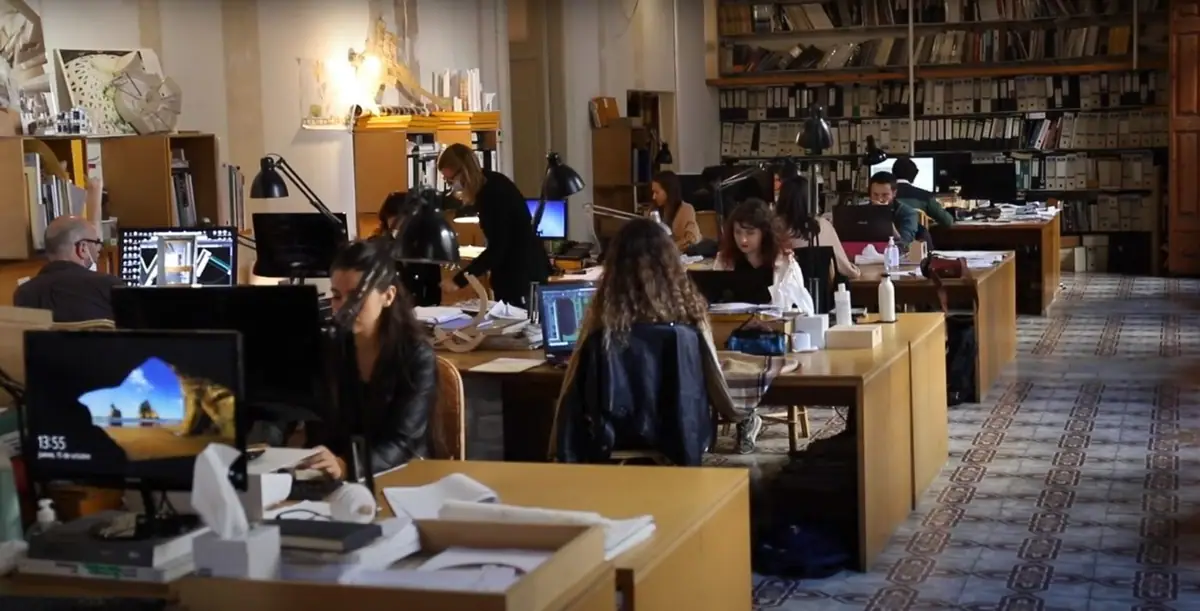 The studio's workroom with wooden desks, computers, archive shelving and encaustic tile flooring