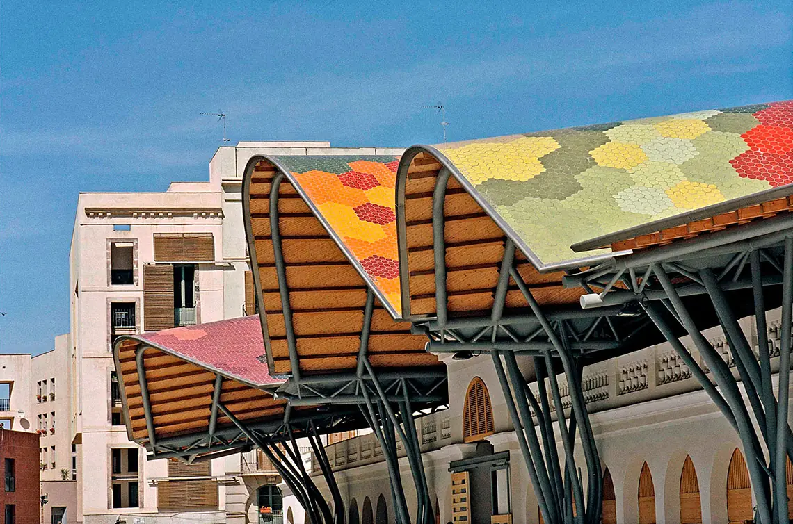 The undulating roof of coloured tiles of the Santa Caterina Market above the old market façade