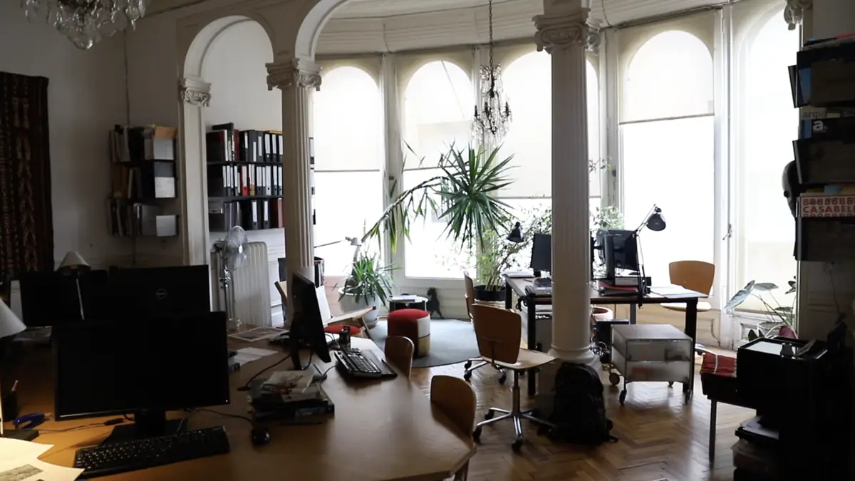 Studio floor with classical columns, worktables and arched windows
