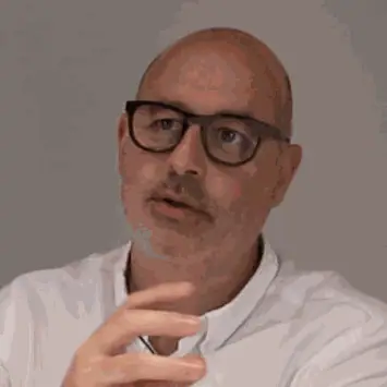 Portrait of Francesc Rifé during the interview, wearing dark-framed glasses and a white shirt