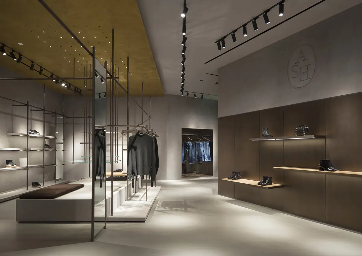 Interior of an ASH store in Shanghai with metal tubular structures, a gold ceiling and wooden shelves