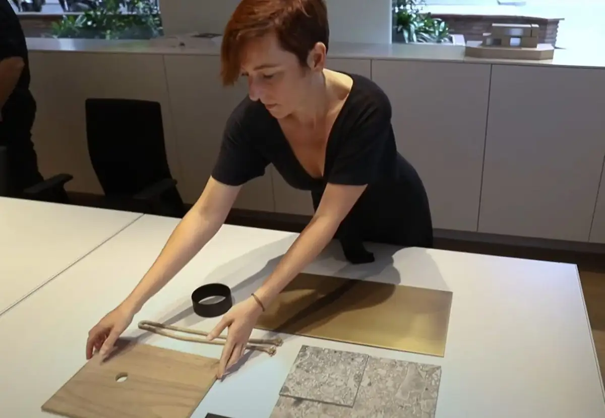 An interior designer lays out wood, metal and stone samples on a studio table