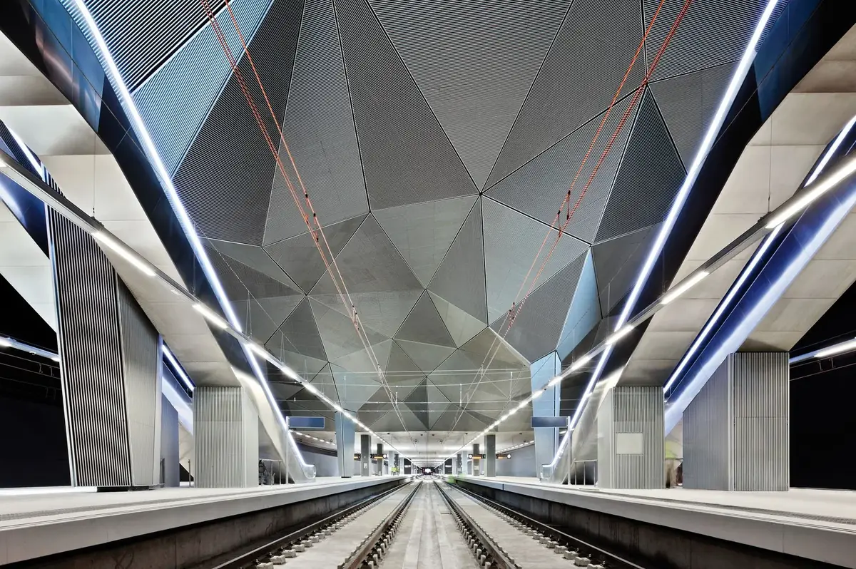 Platforms of the Logroño station beneath a ceiling of faceted panels and strips of light
