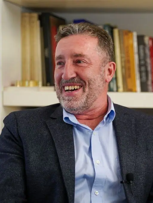 Ángel Pi sonríe durante la entrevista, frente a una estantería de libros