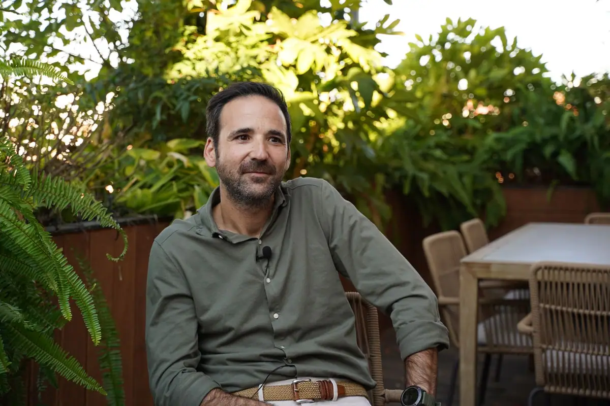 Uno de los socios de Zooco Estudio, sentado en una terraza con plantas, durante la entrevista